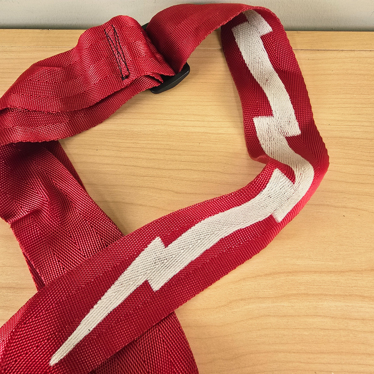 Detail of the white lightning bolt pattern on the red woven strap