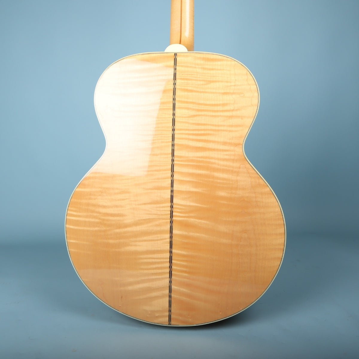 Back view of Gibson J-200 body showing figured flame maple back with center strip inlay.