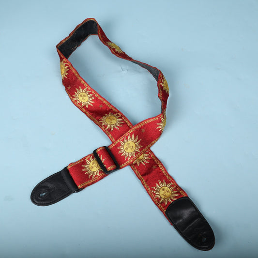 Full front view of the red Levy's MPJG-SUN guitar strap with gold celestial sun pattern