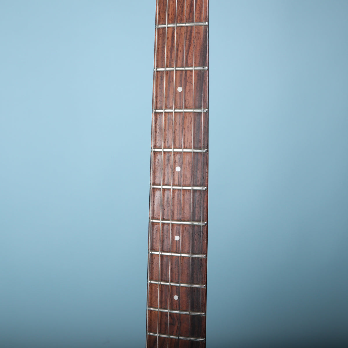 Close-up of the rosewood fretboard with dot inlays and frets.