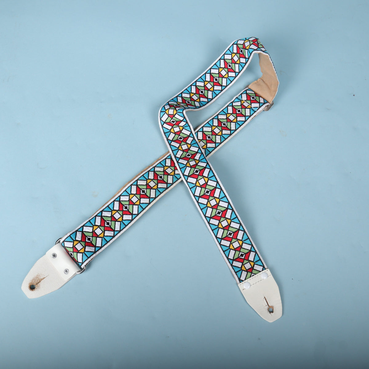 Full display of the Authentic Hendrix guitar strap crossed against a light blue background