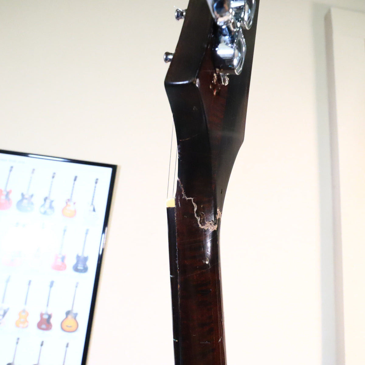 Profile view highlighting the repaired fracture line beneath the nut on the bass side of the neck.