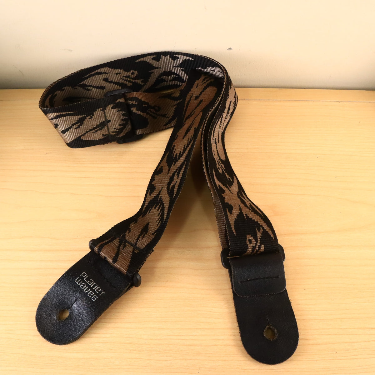 Planet Waves guitar strap showing the full length and leather tabs with stamped logo.