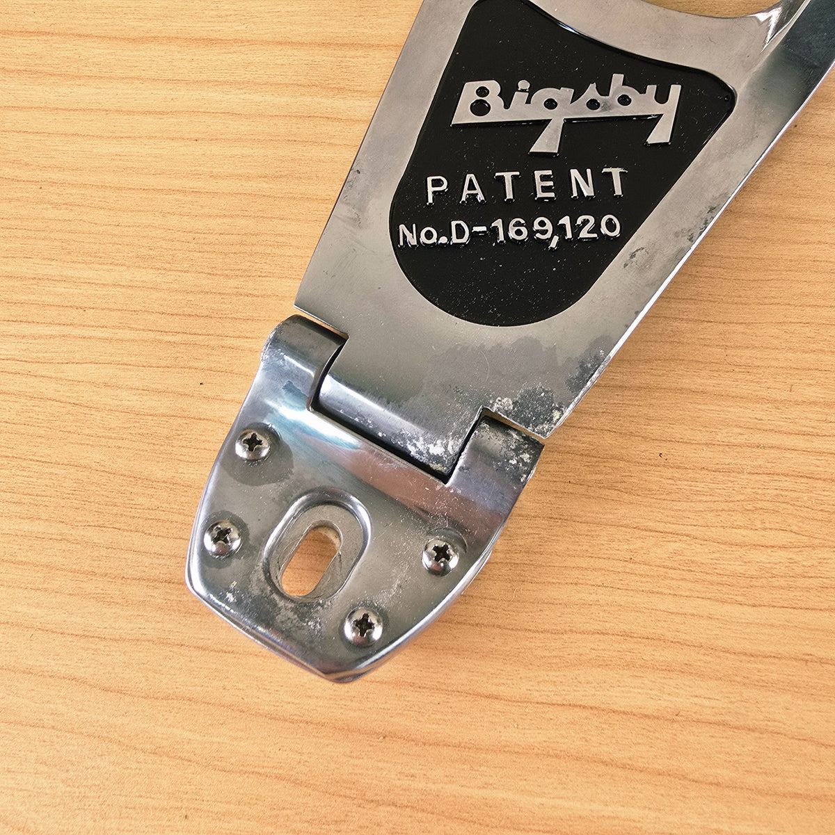 Close-up of the hinge bracket and patent plate detailing surface wear.