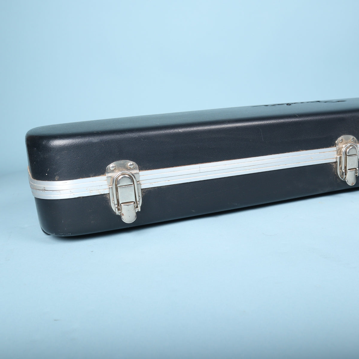Lower end view of Fender molded guitar case showing latch and seam