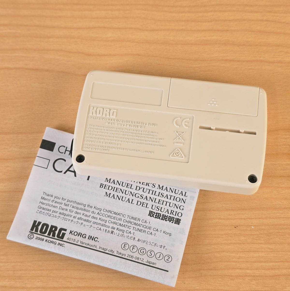 Rear view of the Korg CA-1 chromatic tuner showing battery door and molded product text.