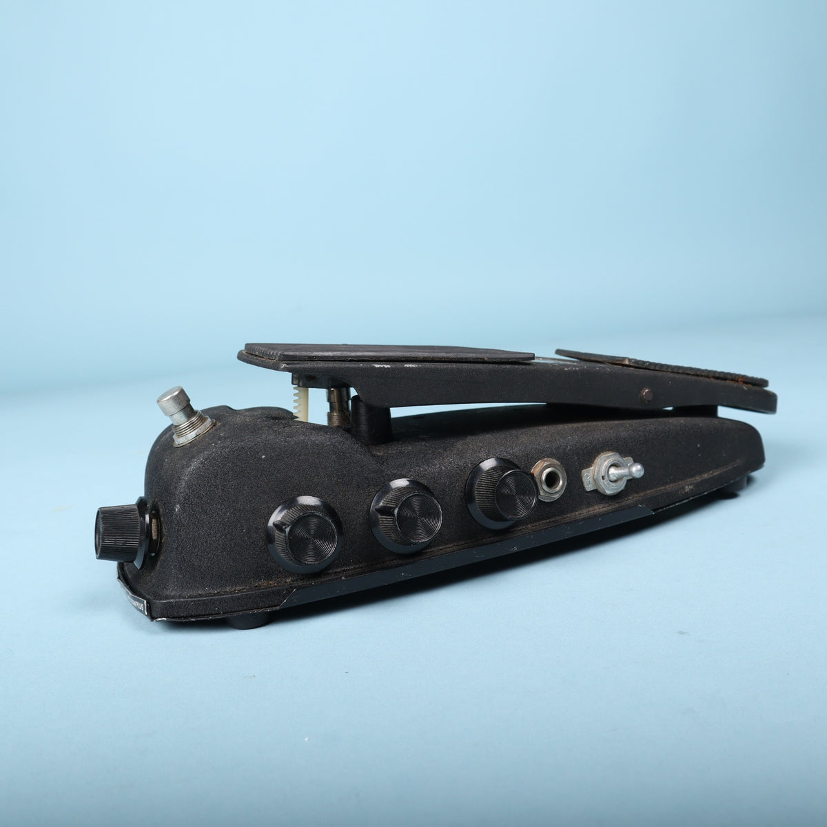 Right side view showing three rotary control knobs, input jack, and toggle switch