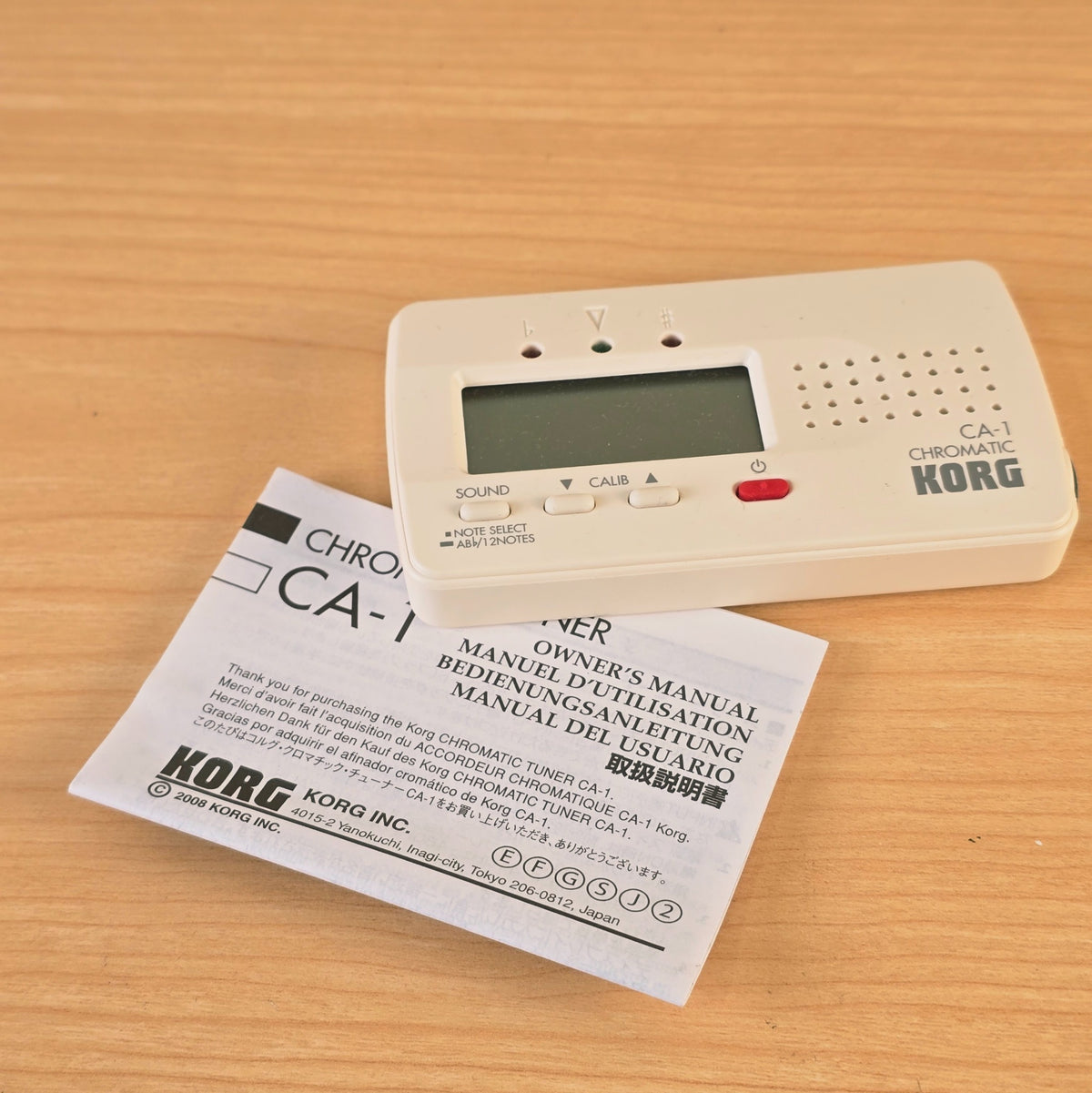 Slightly angled view of the Korg CA-1 chromatic tuner resting on a table surface.