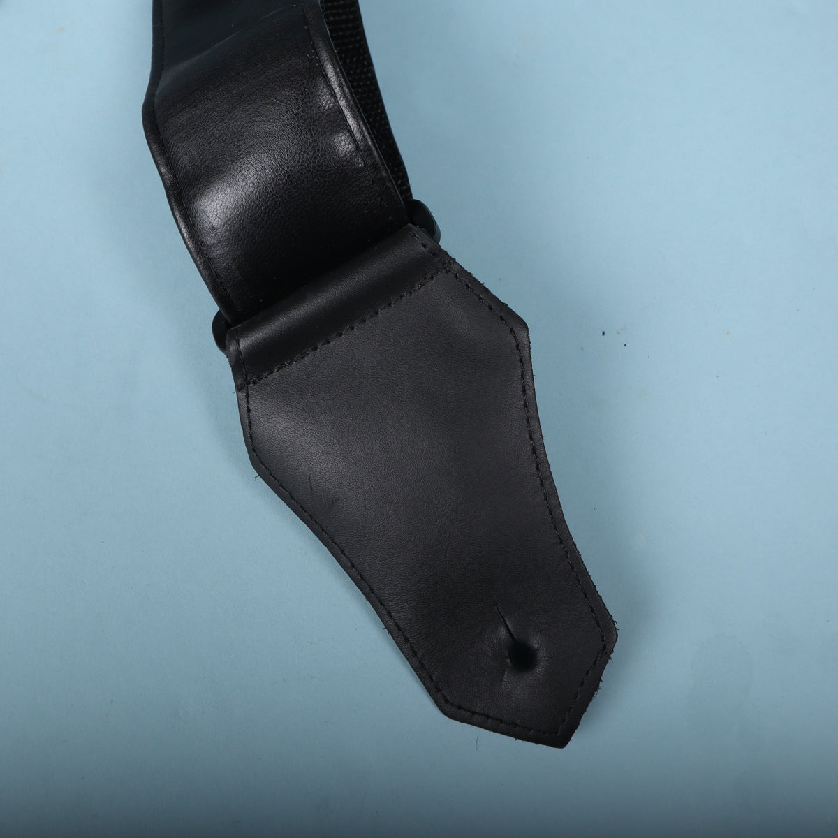 Backside of the leather strap end tab showing the mounting slit