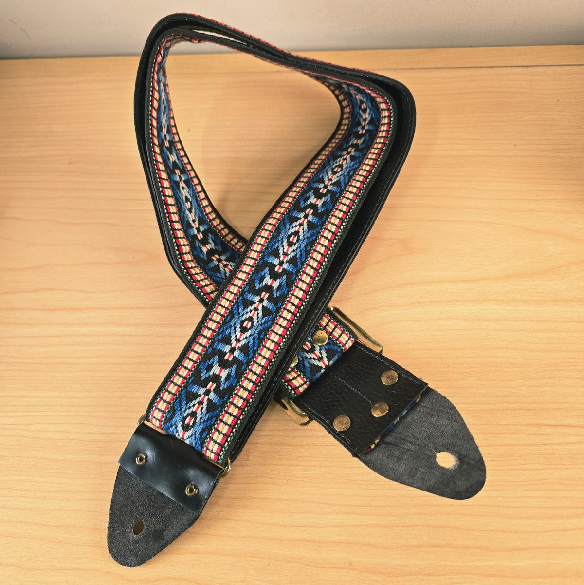 Angle view of the guitar strap showing both leather ends and metal hardware