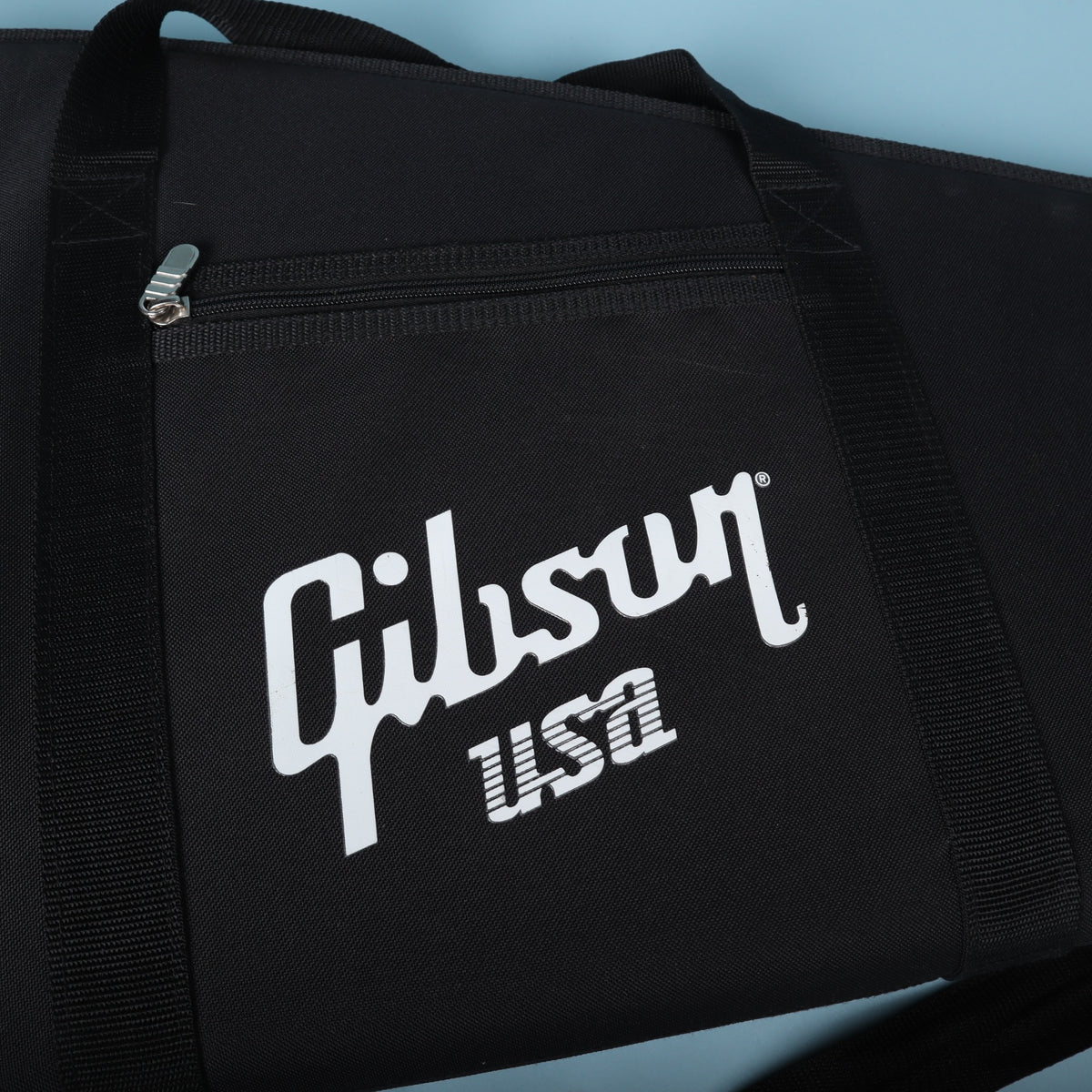 Close-up of the white screen-printed Gibson USA logo and zippered front pouch.