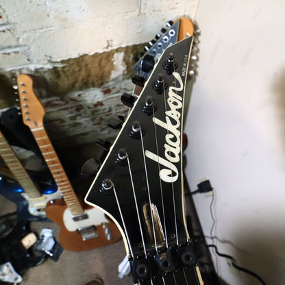 Front view of the pointed Jackson headstock showing the pearl logo and Made in U.S.A. text