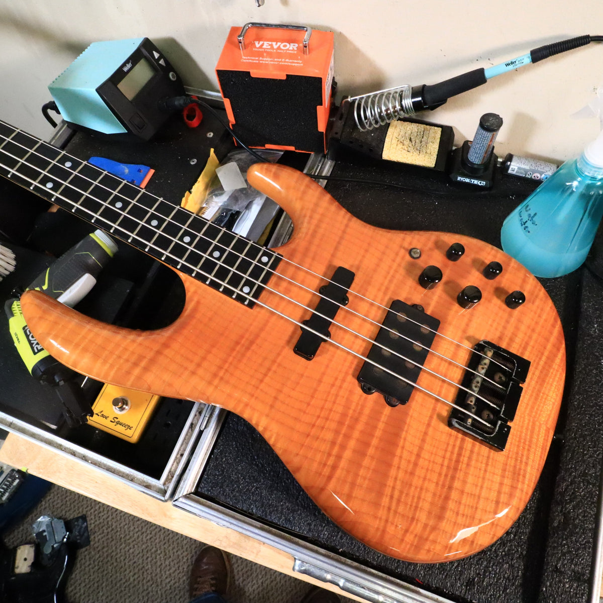 Carvin LB70 bass resting on a technician workbench.