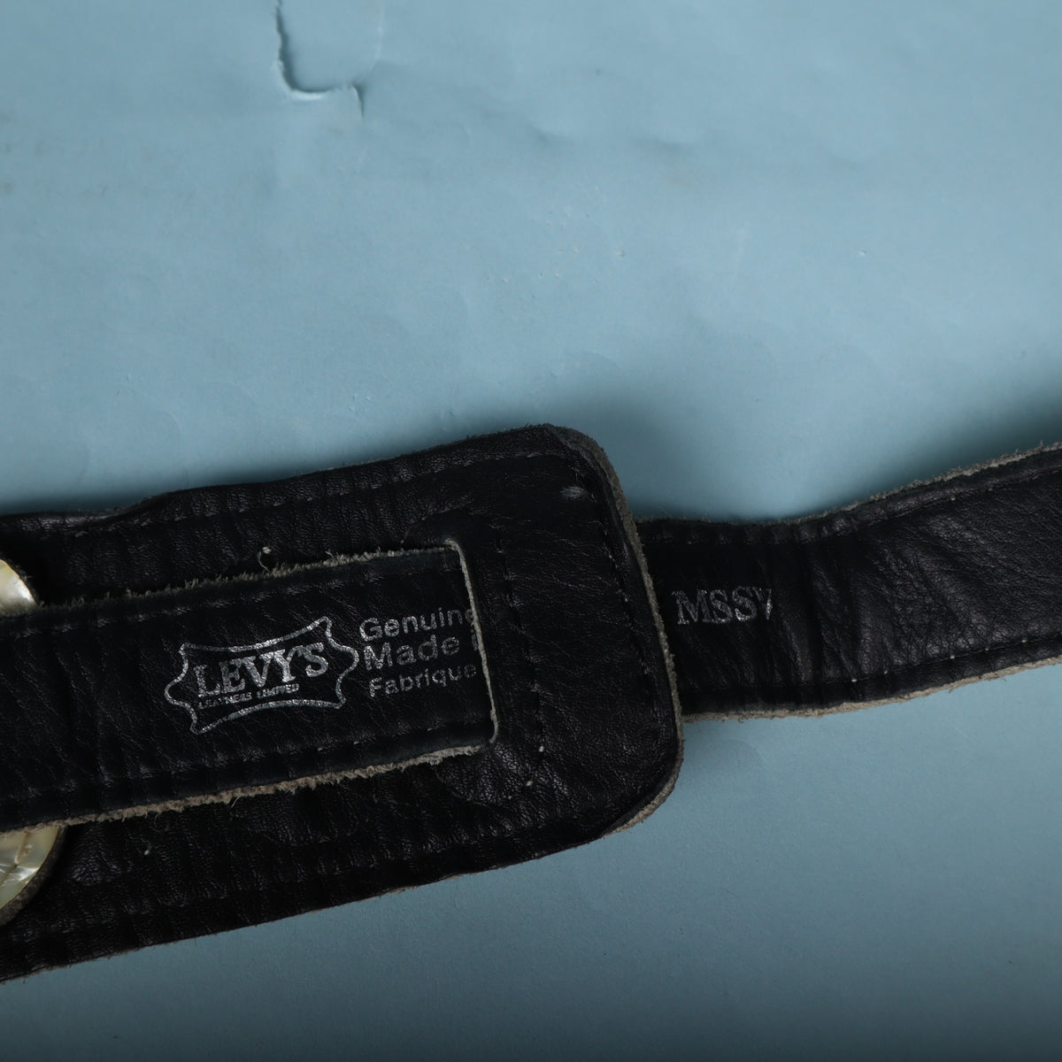 Close-up of the Levy's logo and MSSV model stamp on the black leather strap.