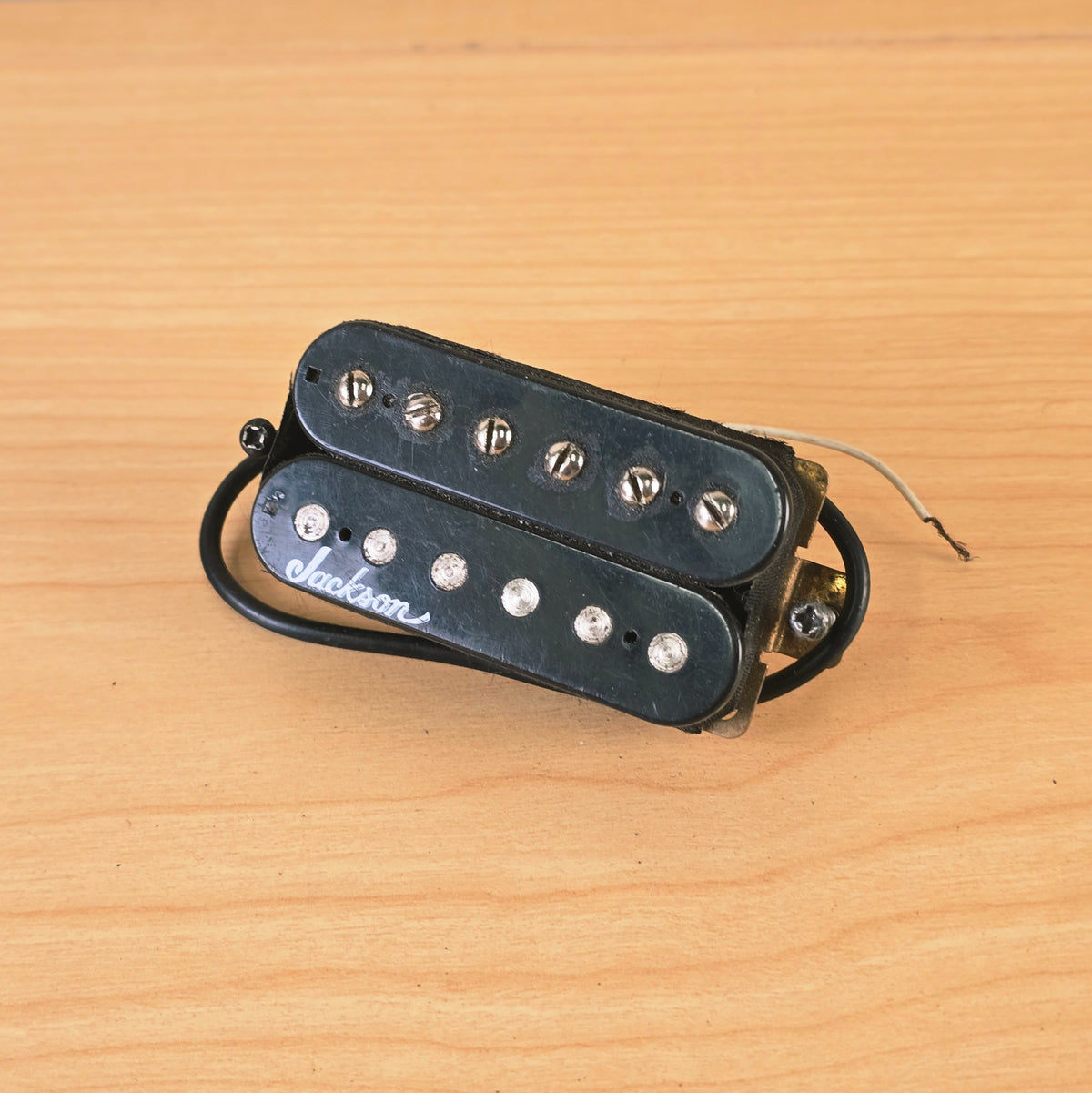 Top view of a black Jackson humbucker pickup with white script logo