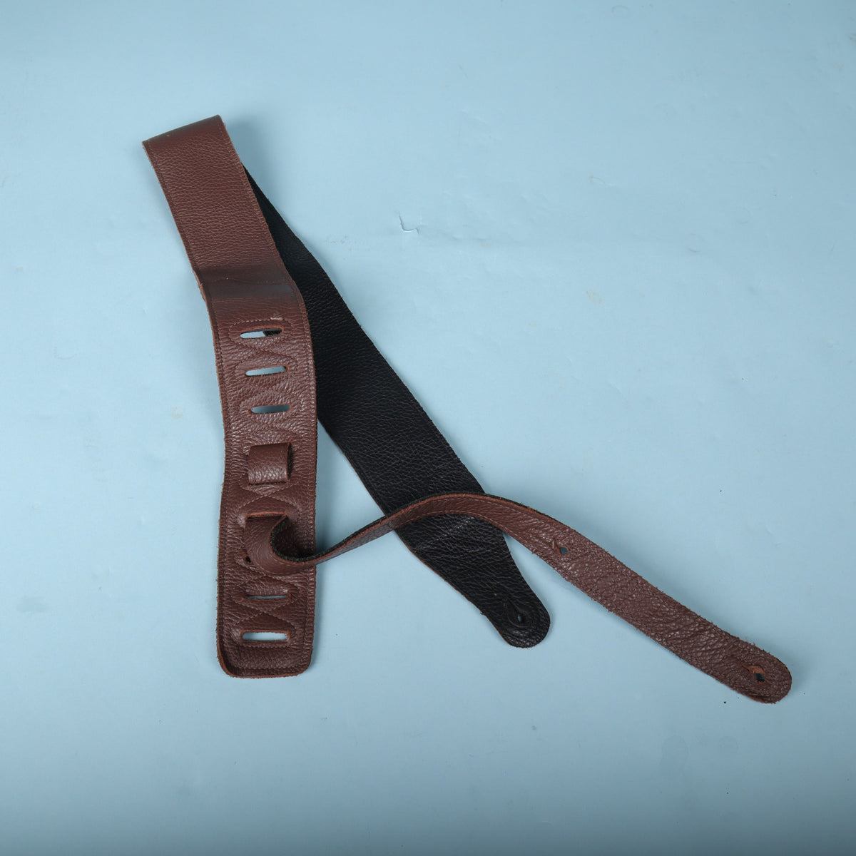 Rear view of the Levy's guitar strap showing the black garment leather backing and adjustment tail
