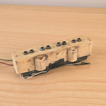 Front angled view of cream bass pickup showing discoloration and surface dirt.