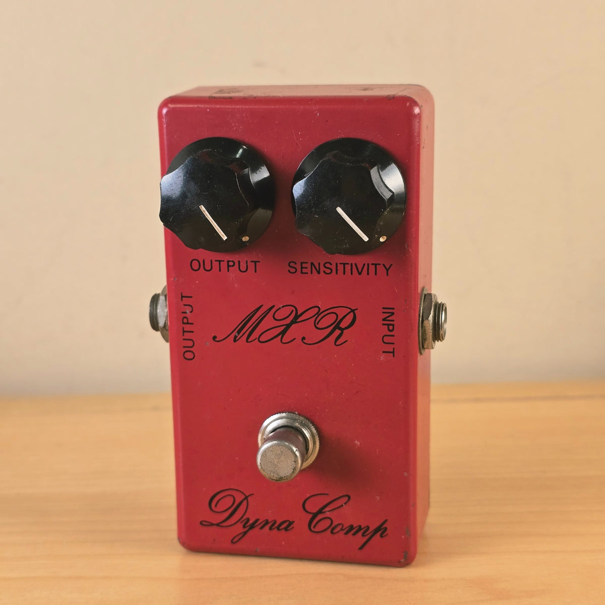 Front full view of a vintage 1970s MXR Dyna Comp script logo compressor pedal in red finish.