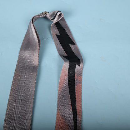 Upper fold of the strap displaying the black lightning bolt motif on grey webbing.