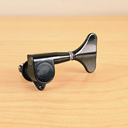 Side profile view of the black Gotoh Modulus bass tuning peg showing the housing and clover key