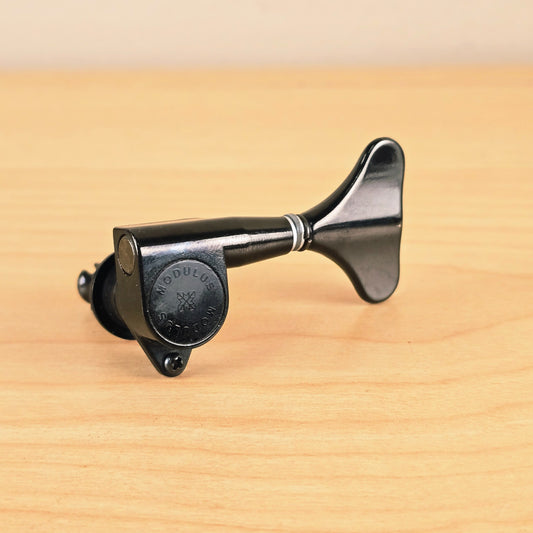 Side profile view of the black Gotoh Modulus bass tuning peg showing the housing and clover key
