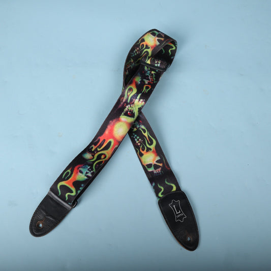 Levy's MPA2 flaming skulls guitar strap laid out against a light blue background.