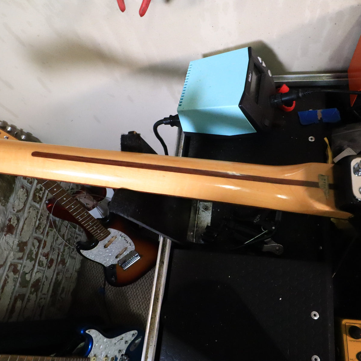 Back of maple neck resting on a bench support.