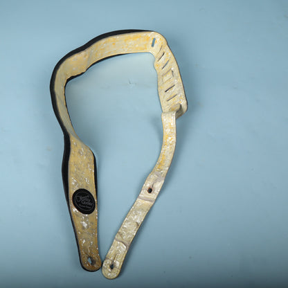 Overall view of the Levy's MSSV Pearloid guitar strap coiled on a blue background.
