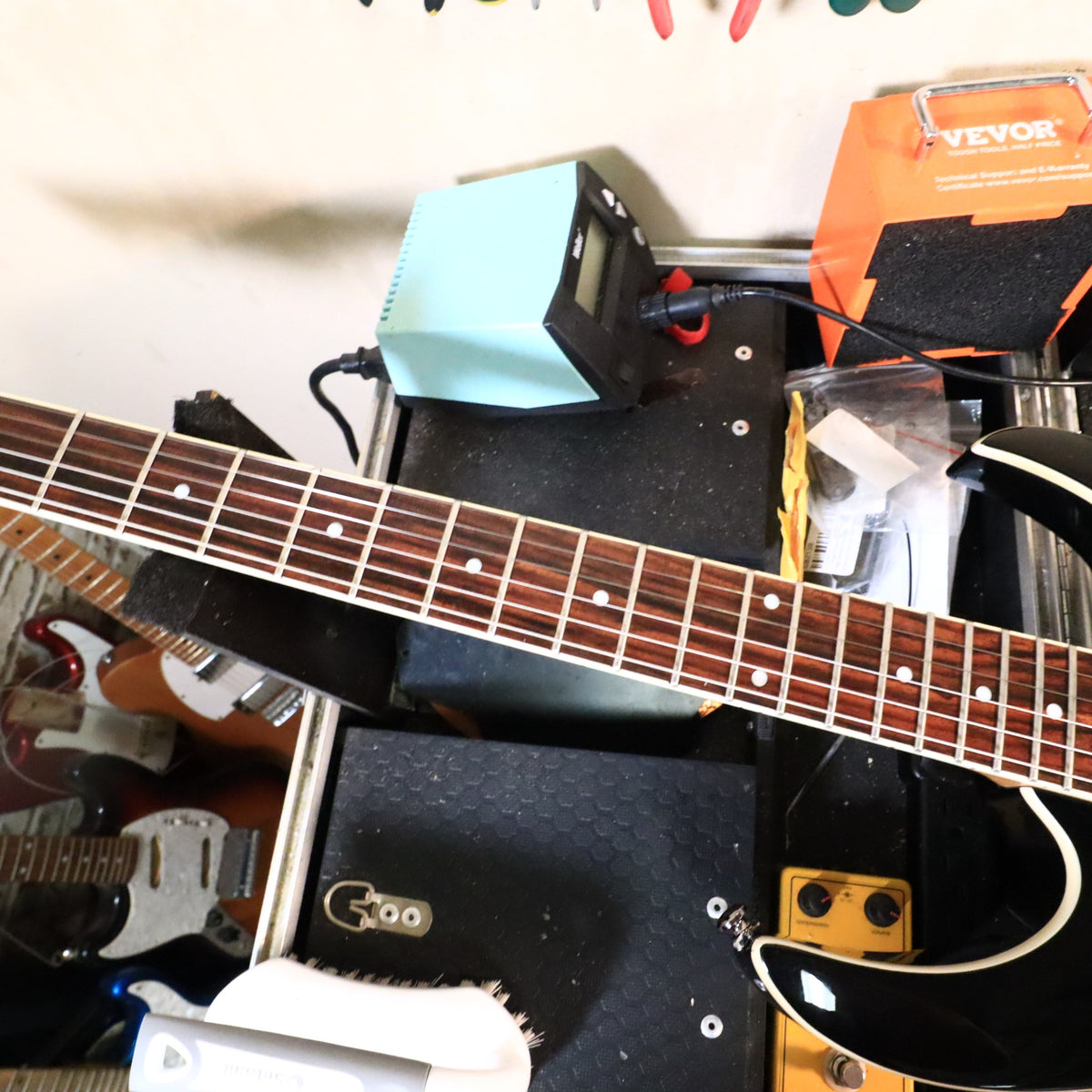 Fretboard view on bench showing frets and white neck binding