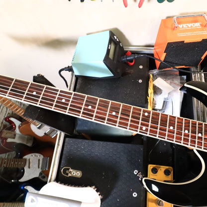 Fretboard view on bench showing frets and white neck binding