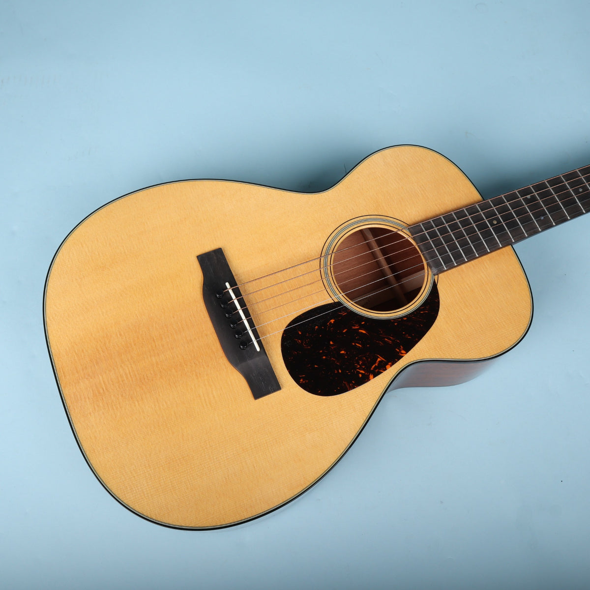 Angled view of the Martin 0-18 body resting horizontally against a blue backdrop.