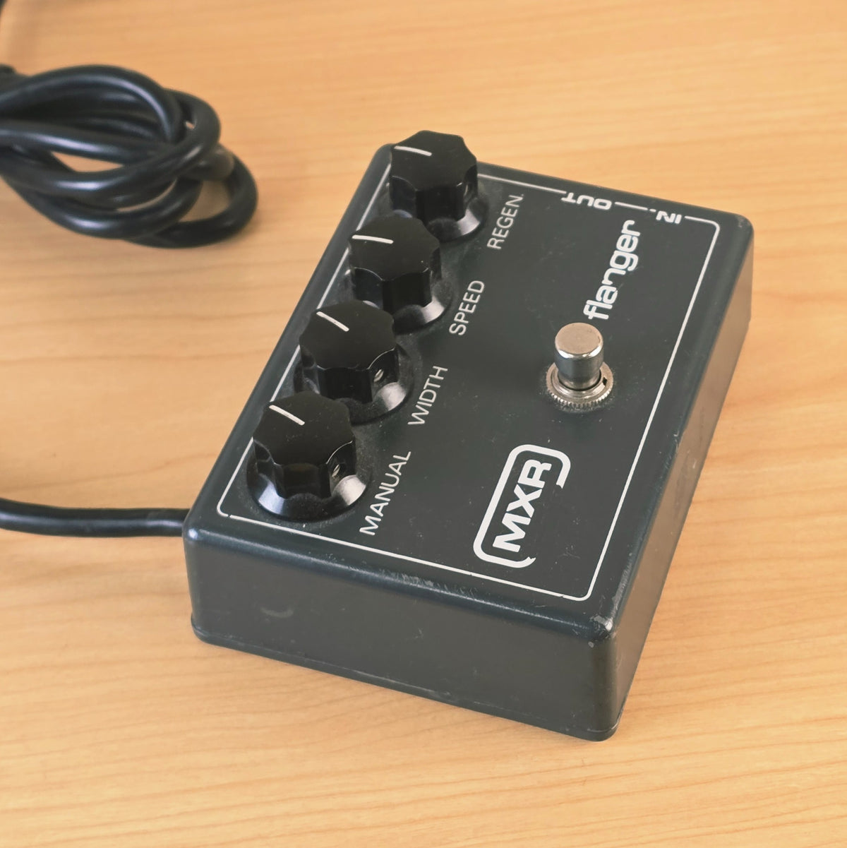 Angled side view of grey MXR Flanger enclosure and footswitch.