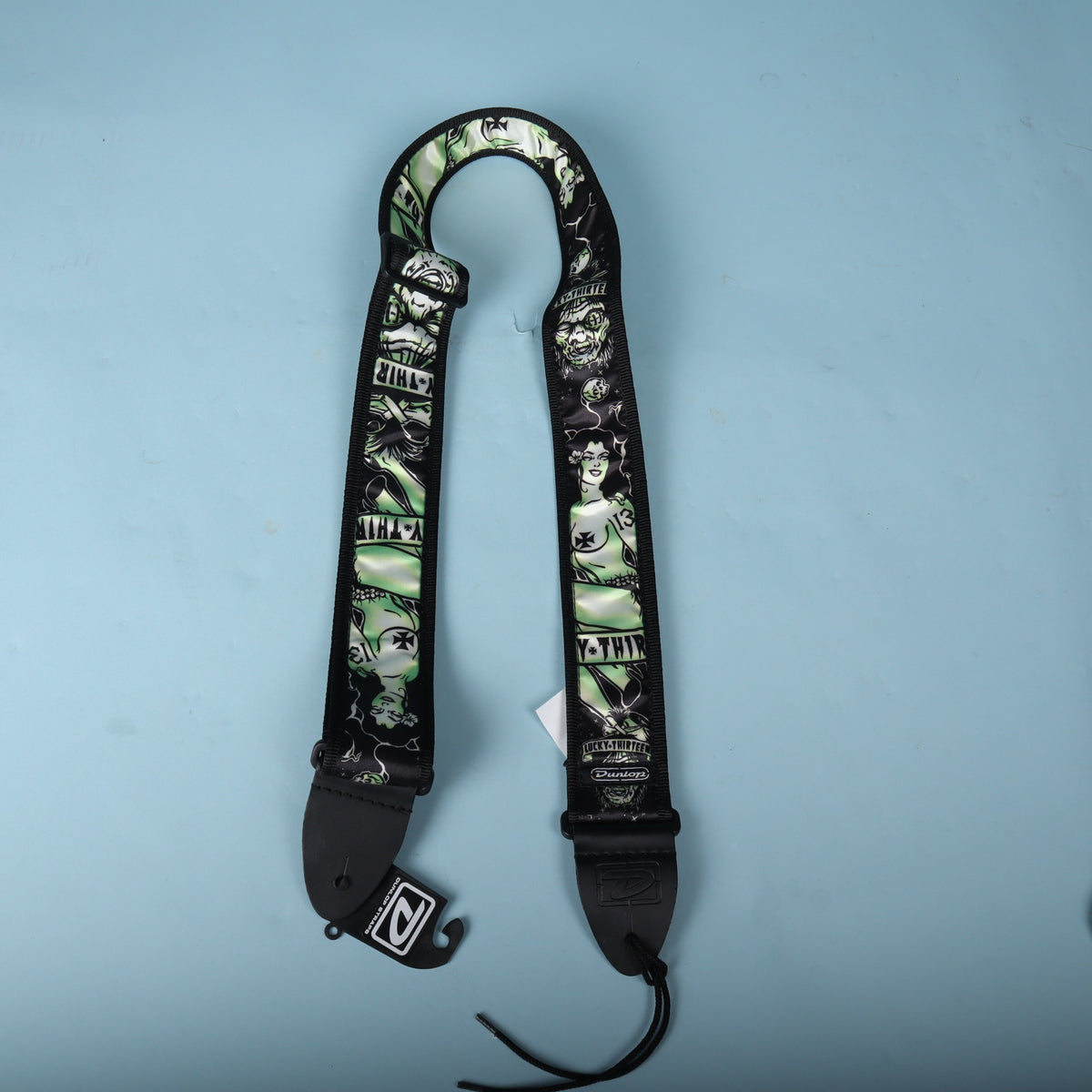 Full arched view of the Dunlop Lucky 13 Dead Island strap showing the complete length and attached lace.