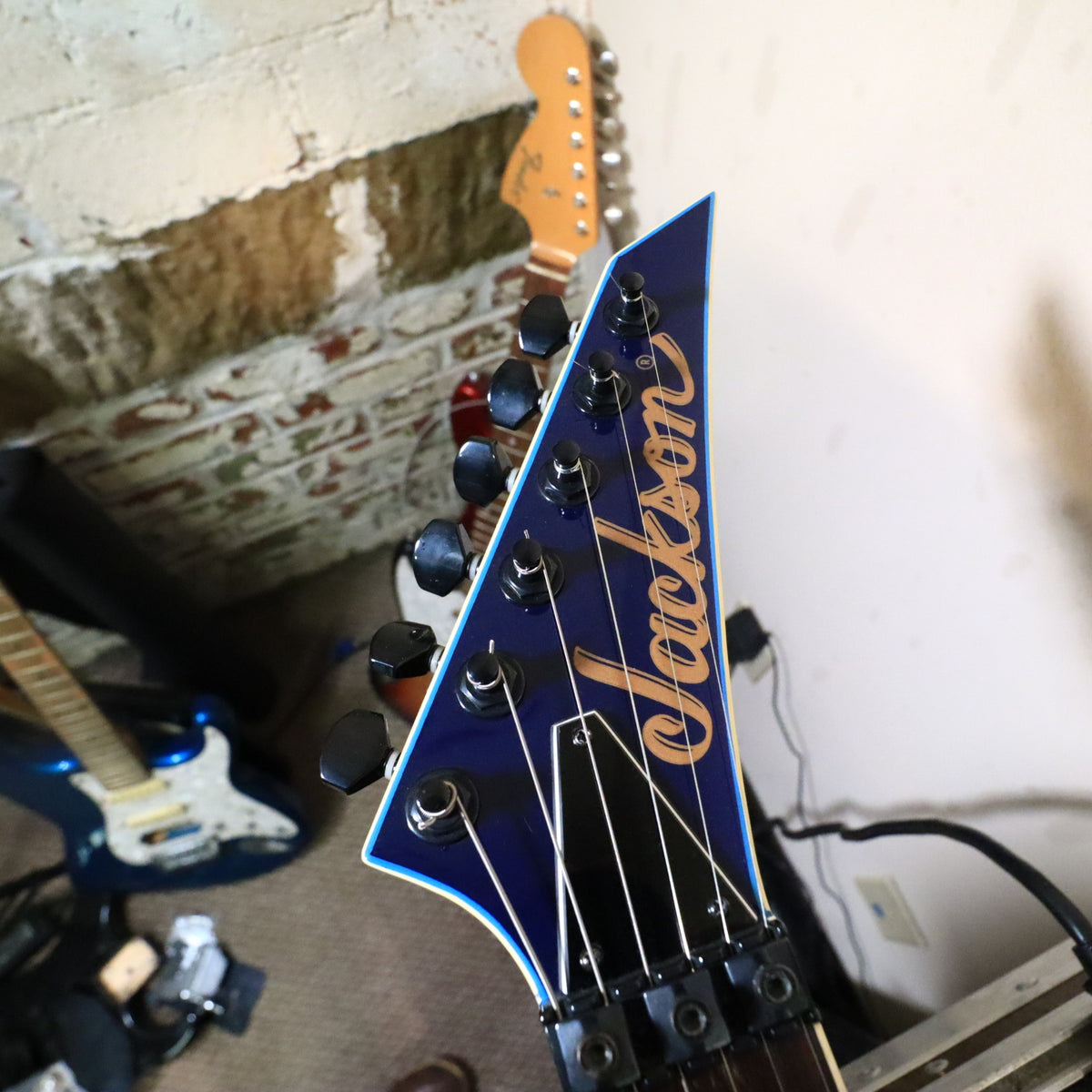 Headstock resting on bench showing Jackson logo and locking nut assembly