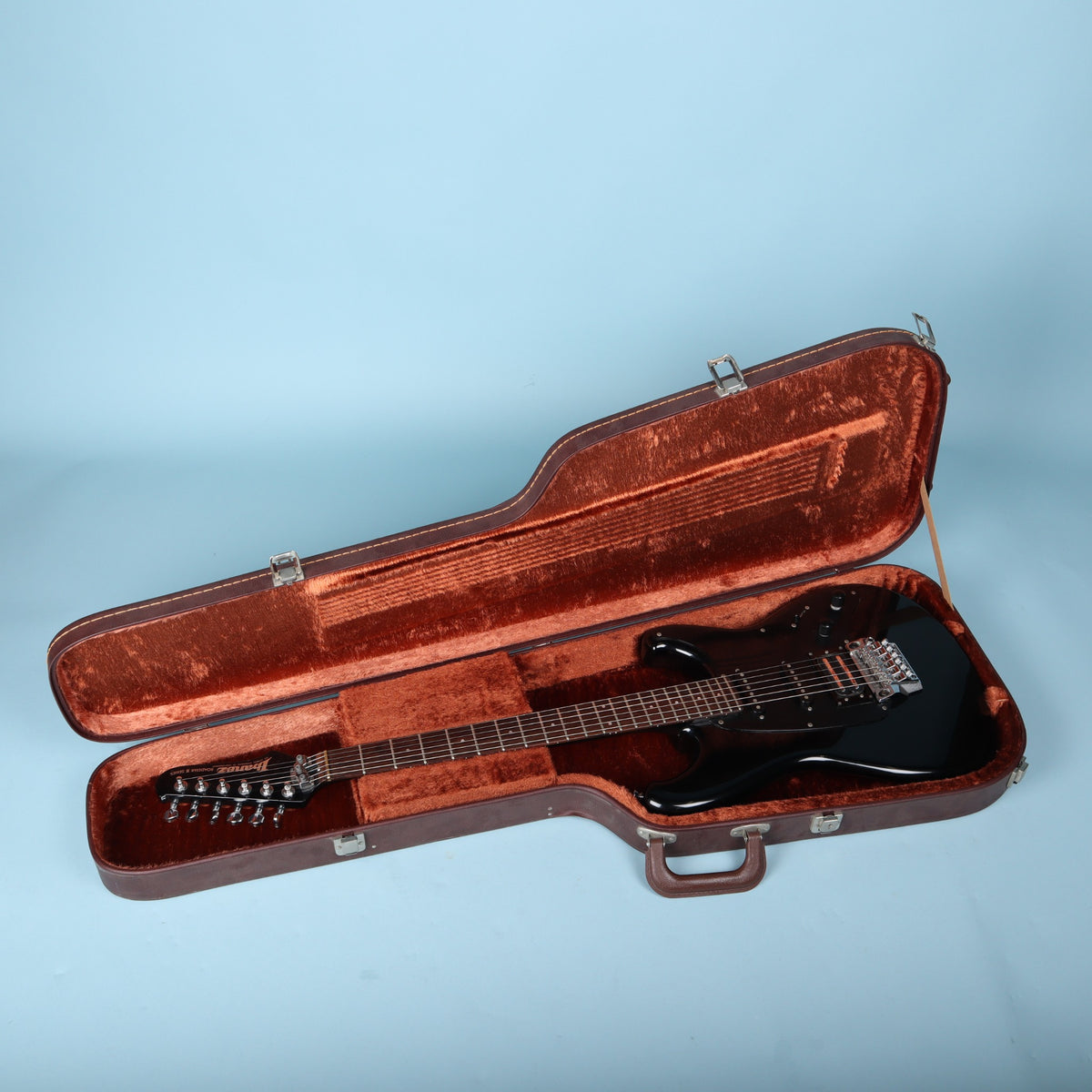 Open Ibanez AH-10 case containing a black Roadstar II guitar for scale reference only.