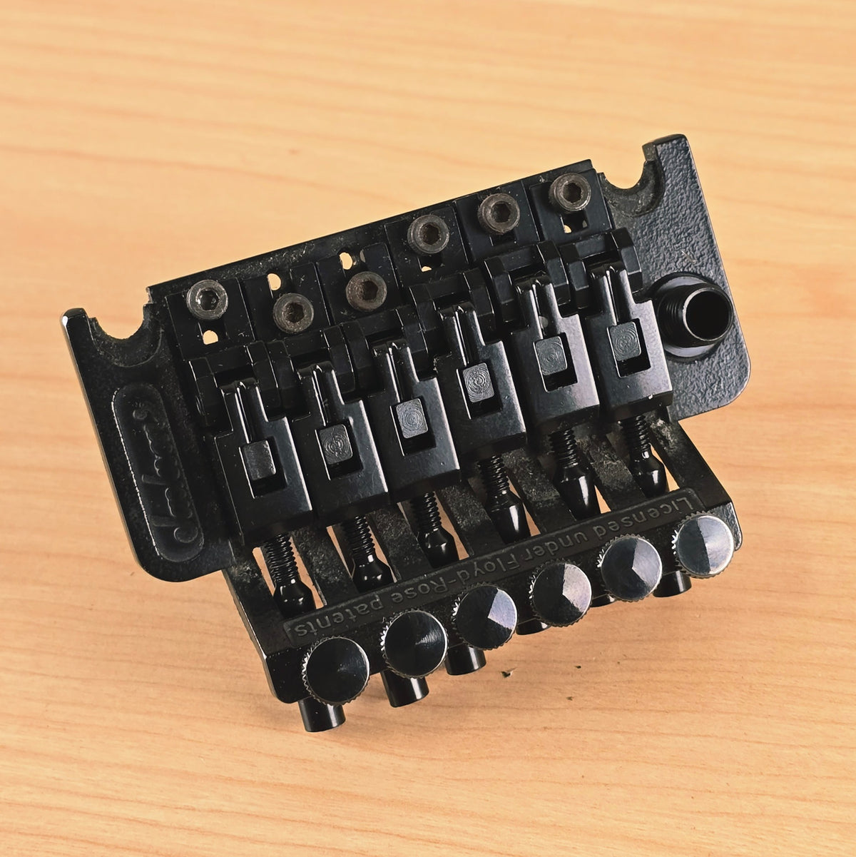 Angled top-down view displaying the black finish and string lock screws.