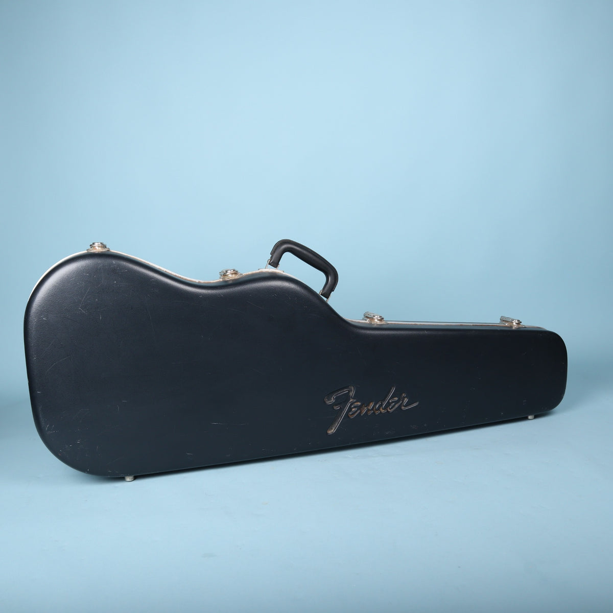2000s Fender molded hardshell guitar case standing upright showing embossed logo