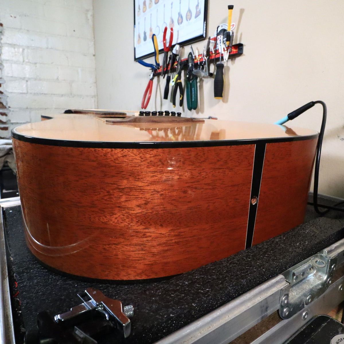 Side view of guitar resting on padded tech workbench