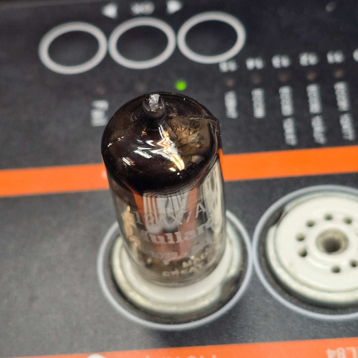 Top-down view of Mullard 12AX7A tube seated in tube tester socket.