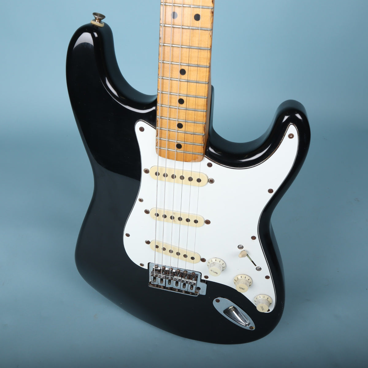 Angled front body close-up of the black Stratocaster