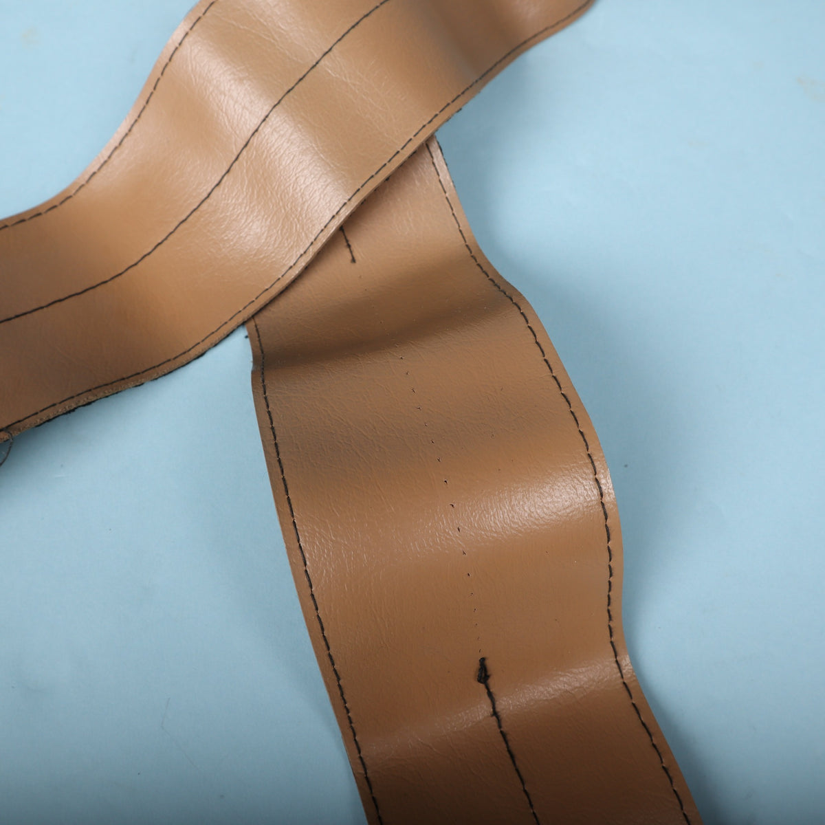 Detail view of the stitching down the center of the tan vinyl shoulder pad section.