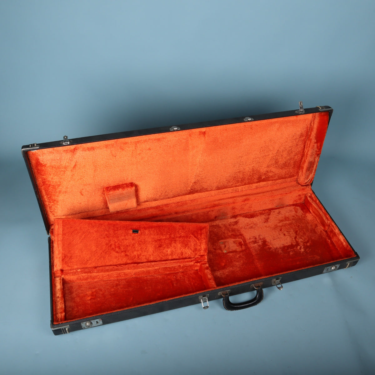Open vintage Fender case with interior accessory compartment lid raised