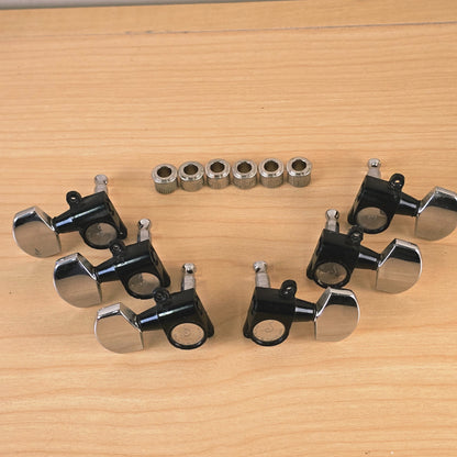 Angular view of six Schaller guitar tuning machines laid out with bushings