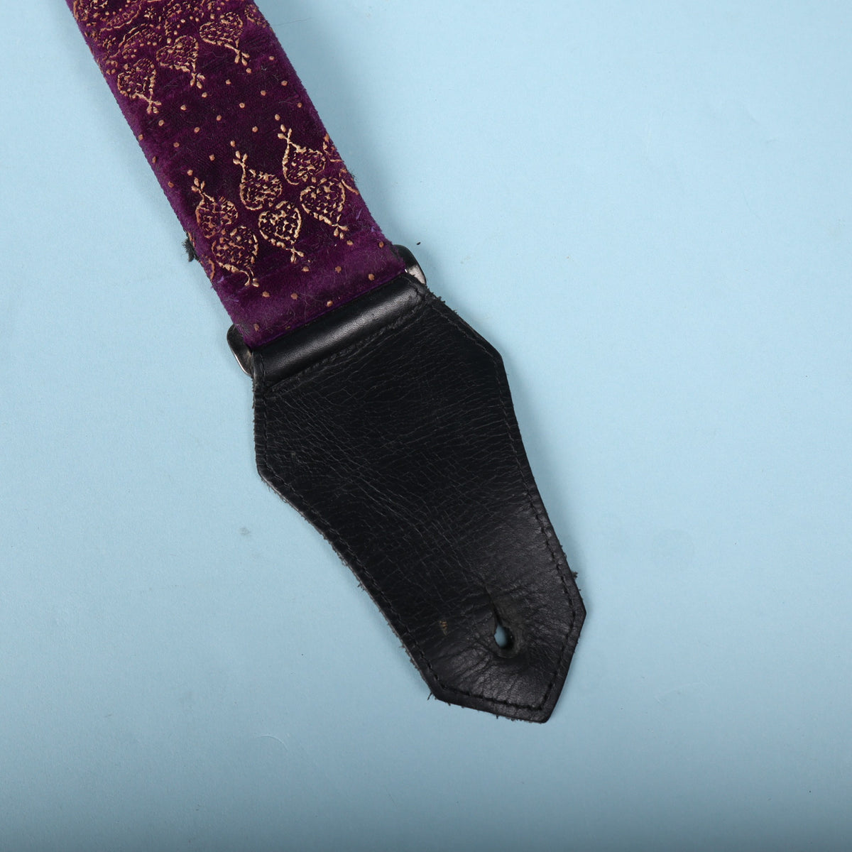 Leather end tab and purple velvet strap section of the Get'm Get'm Indochine guitar strap