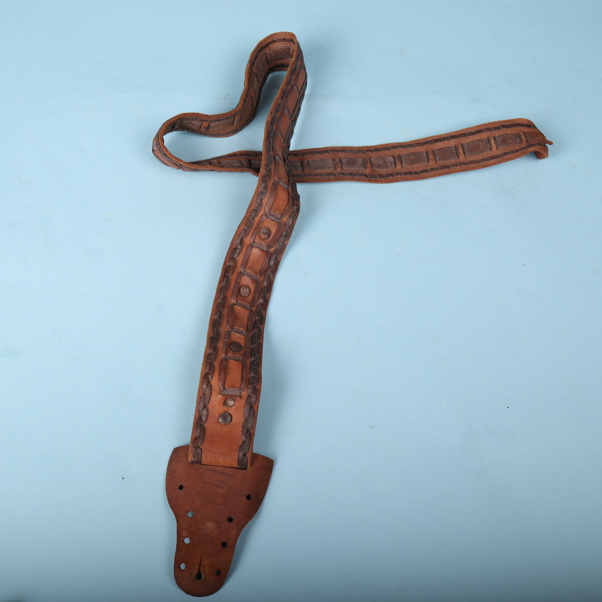 Full view of vintage brown handmade Mexican laced leather guitar strap