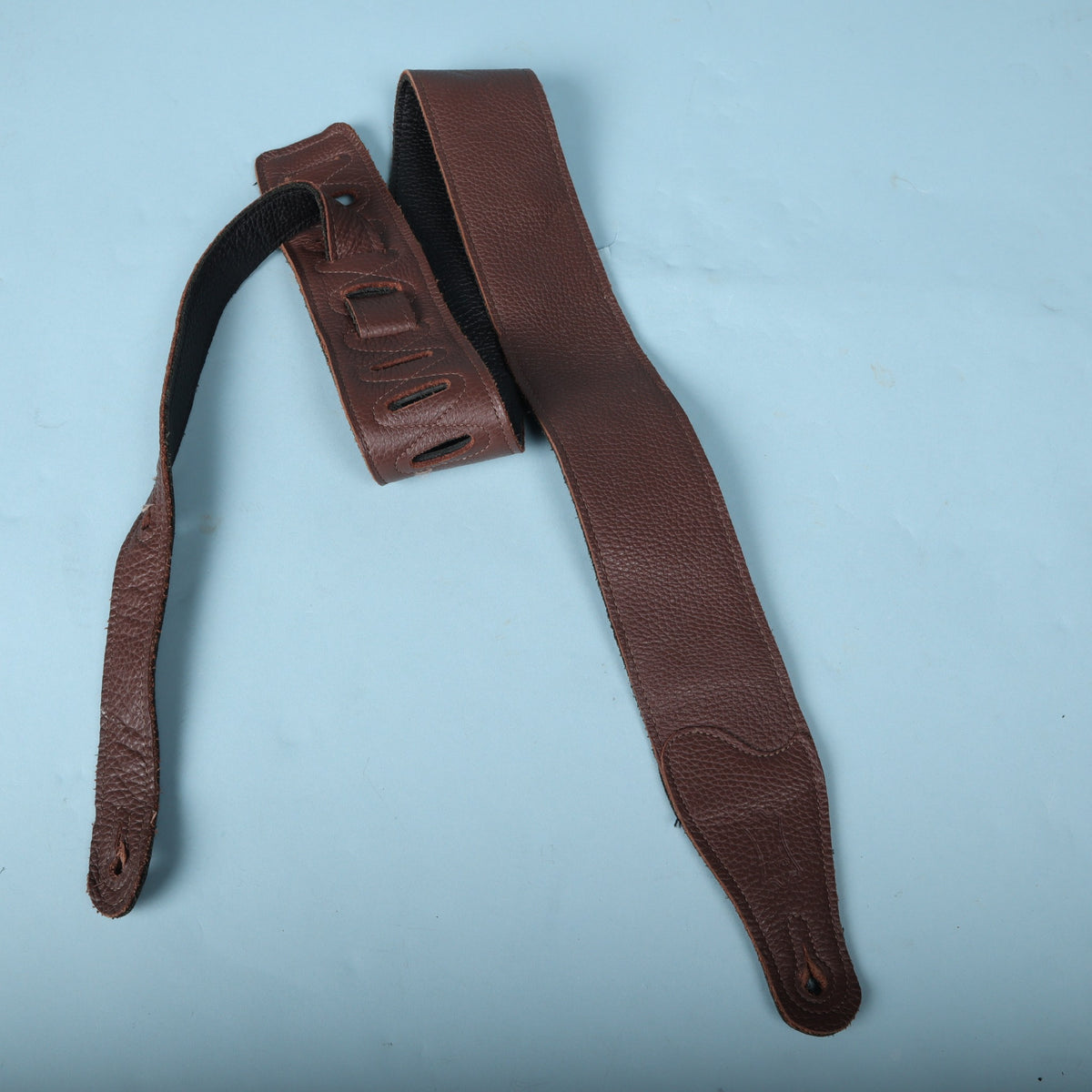Overview of the Levy's brown leather strap laid flat against a blue background