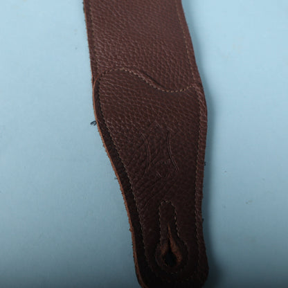 Macro detail of the embossed Levy's crest logo on the pebbled brown leather end