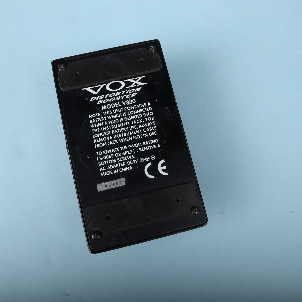 Bottom view of Vox V830 pedal showing label, specifications, and serial number 000485