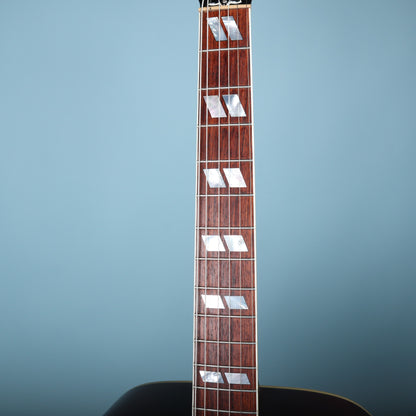 Close-up of the rosewood fretboard and frets against a blue background.