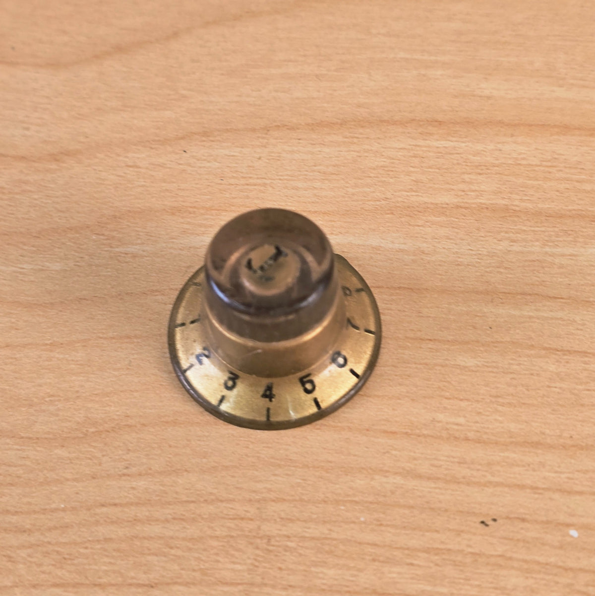 Side angle of gold top hat guitar control knob